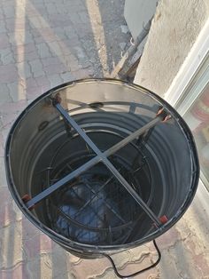 an outdoor fire pit with two tongs sticking out of it's sides and the lid open