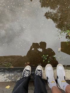 two people standing next to each other with their feet in the water