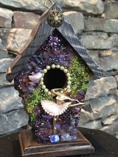 a birdhouse with beads and pearls on it