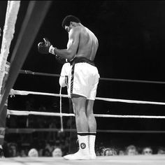 a man standing next to a referee in a boxing ring