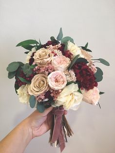 a person holding a bouquet of flowers in their hand