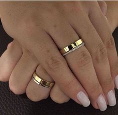 two hands with wedding rings on them, one is holding the other's hand