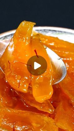 a spoon full of orange peels on top of a plate with a video playing