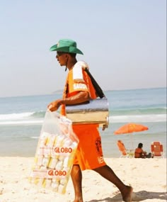 a man walking on the beach carrying food