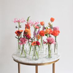 several vases filled with colorful flowers on a marble table