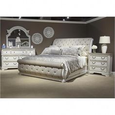 a white bed sitting in a bedroom next to a dresser and mirror on the wall