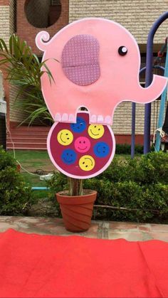 a pink elephant on top of a potted plant