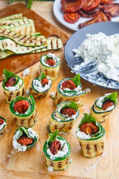 several small appetizers are arranged on a cutting board