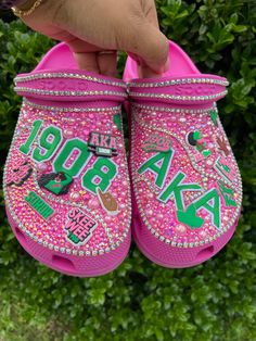 Step into style with our custom Pink and Green AKA Bling Crocs, perfect for any sorority sister or function. These sparkling clogs are a unique and thoughtful gift for her, adding a touch of glam to any outfit. Elevate your footwear game and show off your AKA pride with these dazzling shoes. Aka Crocs, Sorority Shoes, Crocs Custom, Designer Crocs, Bling Crocs, Aka Sorority Gifts, Croc Style, Bedazzled Shoes, Pretty Sneakers