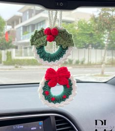 two crocheted wreaths hanging from the dashboard of a car