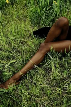 a woman laying in the grass with her legs crossed