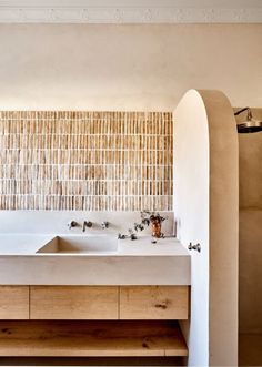 a bathroom with two sinks and a large bamboo wall behind the bathtub is shown