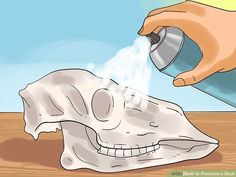 someone spray painting a skull with white paint