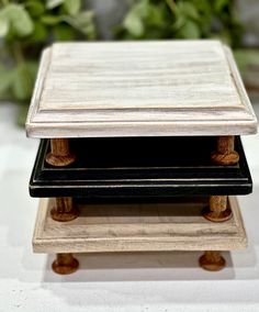 two black and white trays stacked on top of each other with flowers in the background