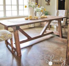 a dining room table with vases and flowers on it