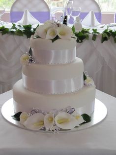 a three tiered wedding cake with white flowers