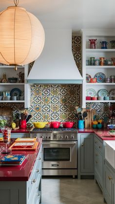 a kitchen with lots of counter space and colorful tile backsplashes on the walls