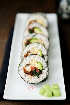 sushi rolls are arranged on a white plate