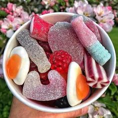 a bowl filled with lots of different types of candies and fruit on top of each other