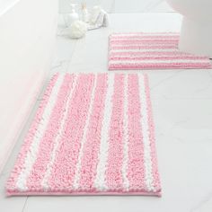 two pink and white bathroom rugs on the floor