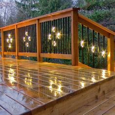 a wooden deck with lights on it and some trees in the backgroung