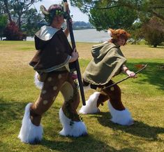 two people dressed up in costumes and standing on the grass