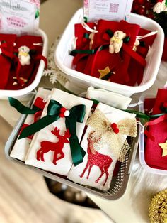 three baskets filled with red and green christmas gift wrapped in white paper on top of a table