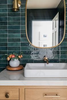 a white sink sitting under a mirror in a bathroom next to a wooden counter top