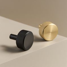 two black and gold knobs on a white surface