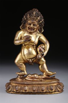 a gold statue of a man holding a ball