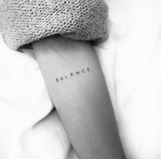 a woman's arm with the word balance tattooed on her left arm, in black and white