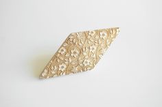 a piece of wood that has been carved into the shape of a triangle with flowers on it