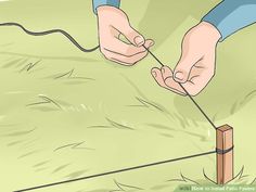 a person is trying to wire a fence with two hands on top of the pole