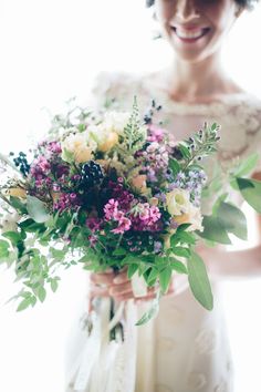 a woman holding a bouquet of flowers in her hands