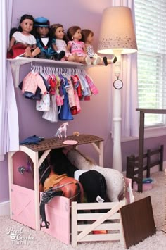 there is a shelf with dolls and clothes on it