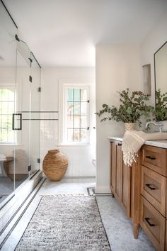 a bathroom with white walls and wooden cabinets