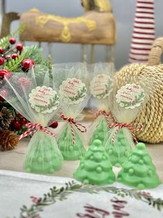 small green christmas trees are sitting on a table next to pine cones and candy canes