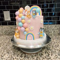 a birthday cake decorated with cartoon characters and balloons