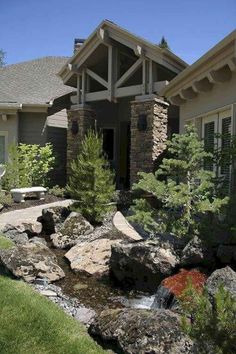 a house that has rocks in front of it and trees around the outside area,