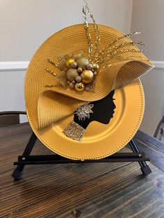 a yellow plate topped with a golden hat and gold baubles on top of it