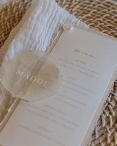 a menu sitting on top of a wicker basket next to a white napkin and fork