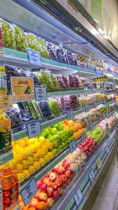 an aisle in a grocery store filled with lots of fresh fruits and veggies