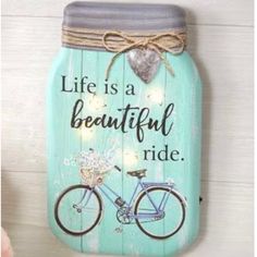 a blue mason jar with a bicycle painted on the front and words life is a beautiful ride