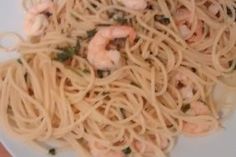 a white plate topped with pasta and shrimp