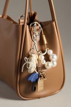 Charming new-trend alert: jewelry for your bag, featuring a thread-wrapped carabiner and pearl-decorated chain, perfect for stacking multiple charms. | Rope Carabiner Bag Charm by Anthropologie in Grey, Women's, Polyester/Brass/Resin Mini Bag Design, Purse Jewelry Key Chains, Purses With Charms, Bags With Keychain, Handbag Charms Aesthetic, Bag Charm Inspiration, Birkin Bag Charms, How To Make Bag Charms