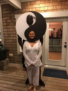 a woman standing in front of a door with a giant yin sign on her head