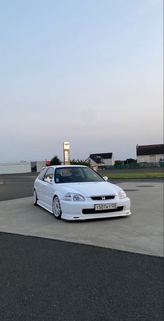 a white car parked on top of a parking lot