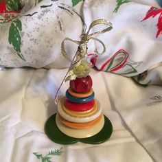 a stack of colorful wooden toys sitting on top of a white bed cover covered in christmas decorations