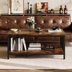 a living room with a brown leather couch and coffee table in front of the couch