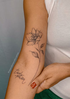 a woman with a flower tattoo on her arm